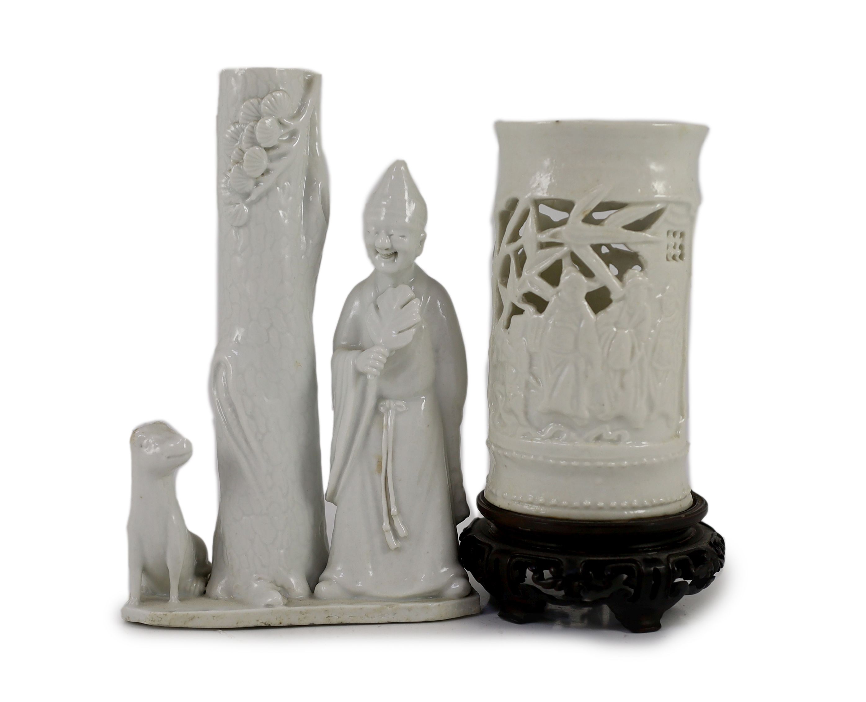 A Chinese blanc-de-chine figural joss stick holder and a similar brushpot, Dehua kilns, 18th/19th century, 16cm high & 11cm plus wood stand